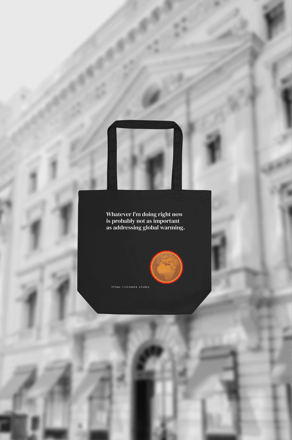 Black tote bag with climate message against fashion house background