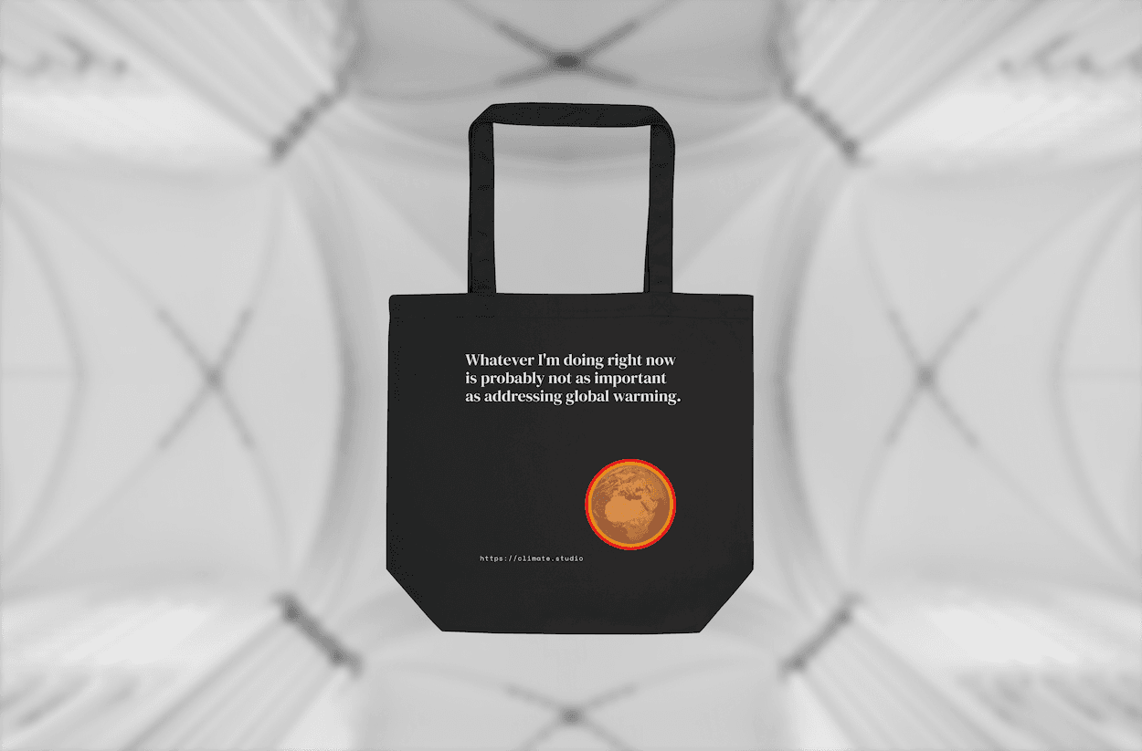 Black tote bag with climate message against architecture background