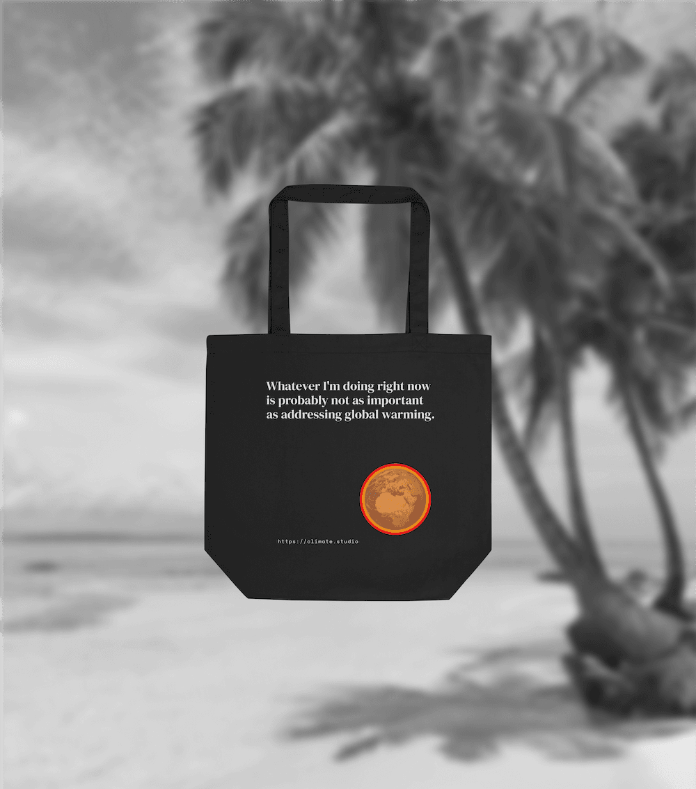 Black tote bag with climate message against beach background