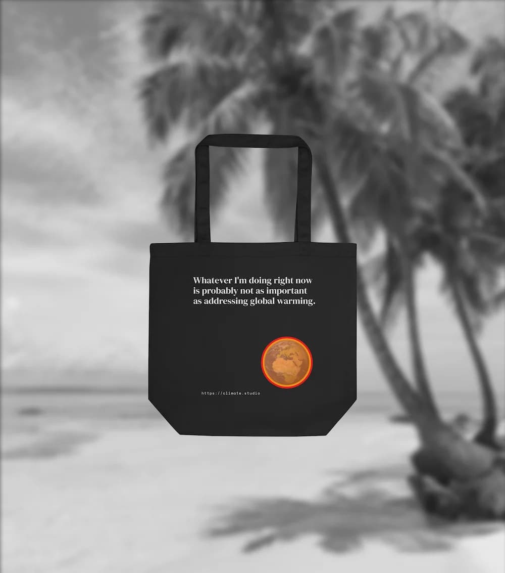 Black tote bag with climate message against beach background