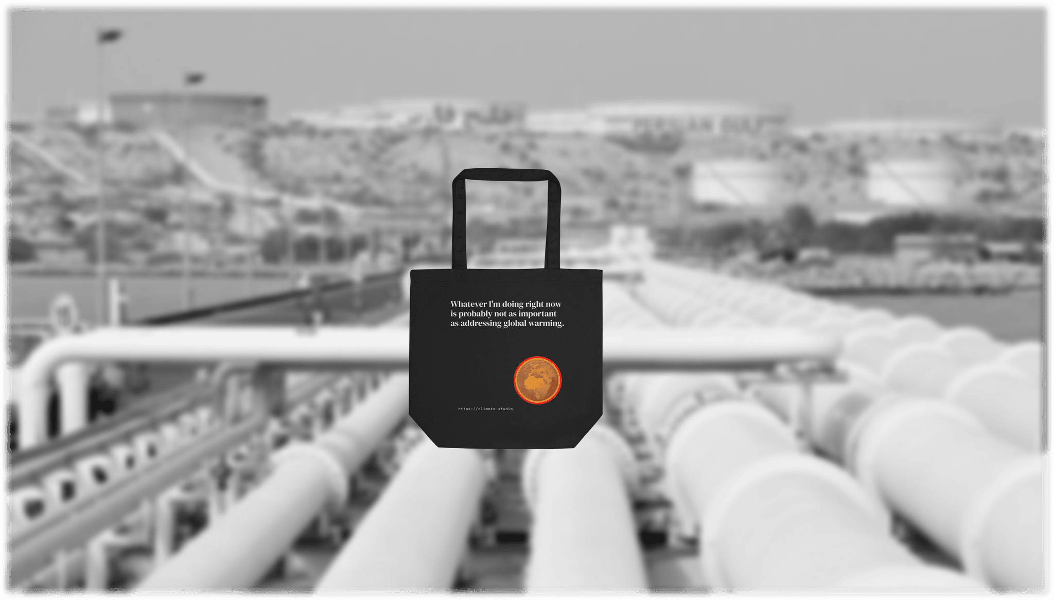 Black tote bag with climate message against oil pipeline background