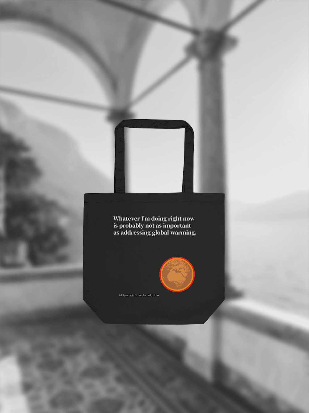 Black tote bag with climate message against Lake Como background